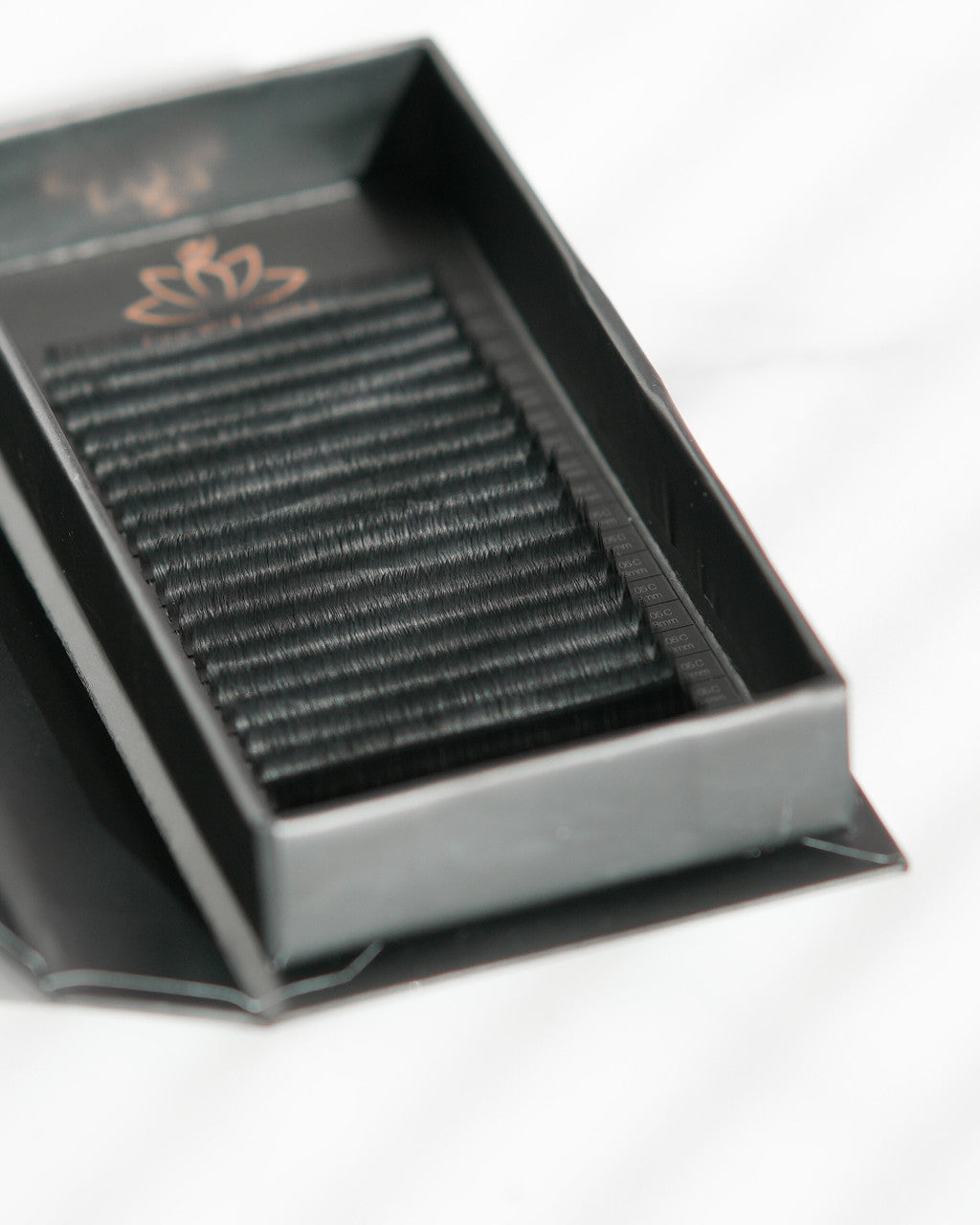 Beutimi FauxMink Lashes 0.03MM displayed in open black and white packaging tray with individual lash strips arranged in rows