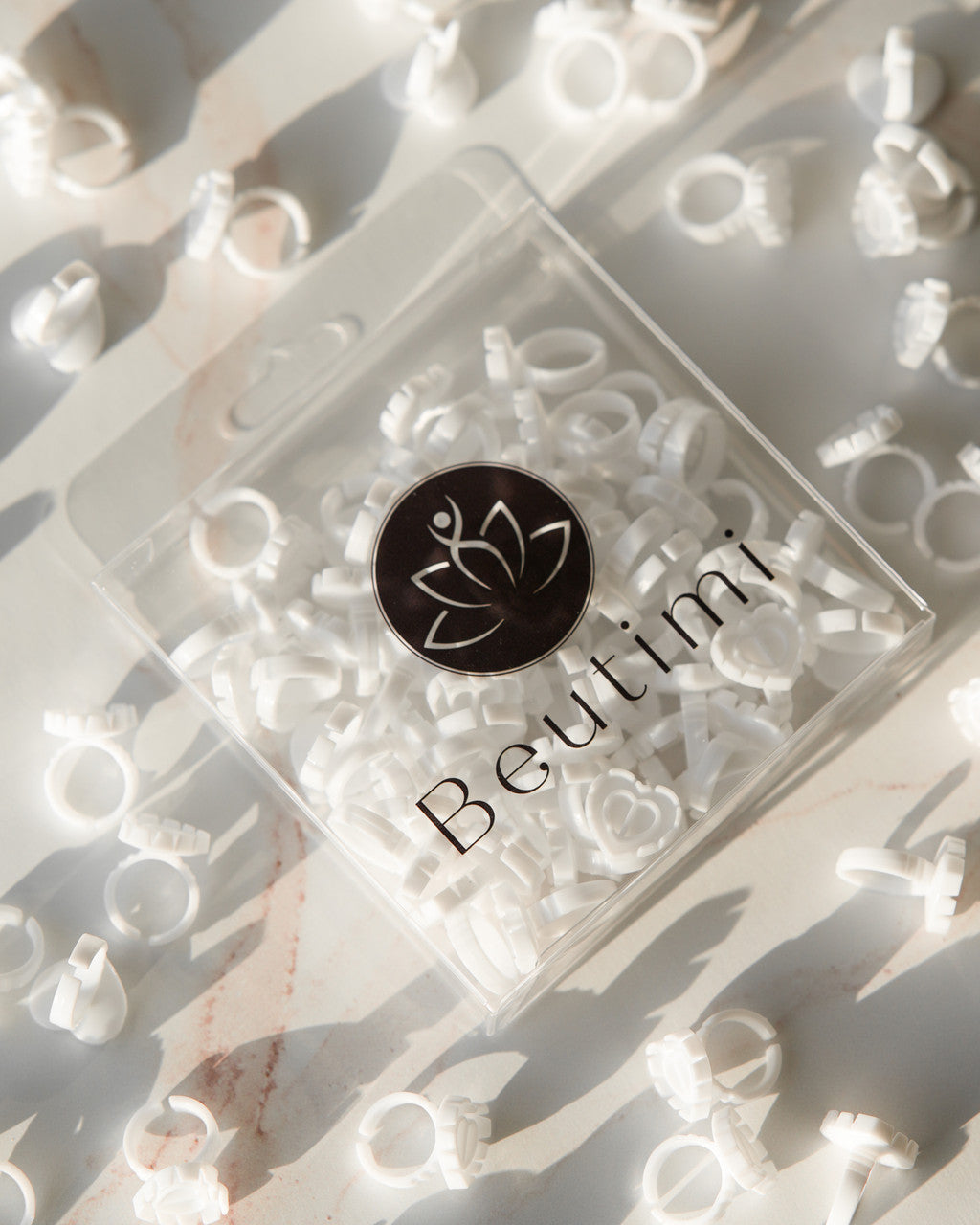 Beutimi Brave Hearts Ring pack displayed flat lay with 50 white disposable heart-shaped glue rings arranged on marble surface