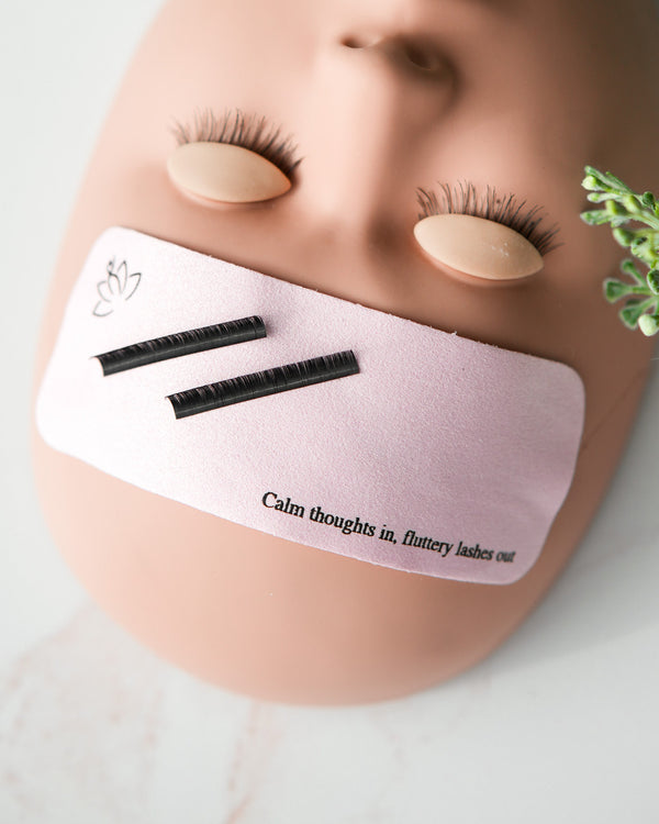 Beutimi Forehead Cover in pink displayed on a mannequin head showing two black lash strips and motivational text
