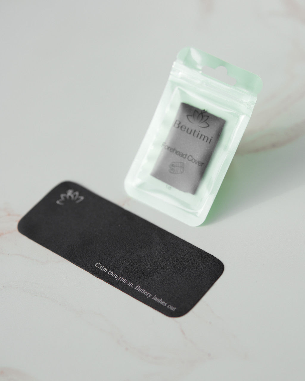 Beutimi Forehead Cover displayed in black and white packaging showing the product with affirmation text and lotus logo
