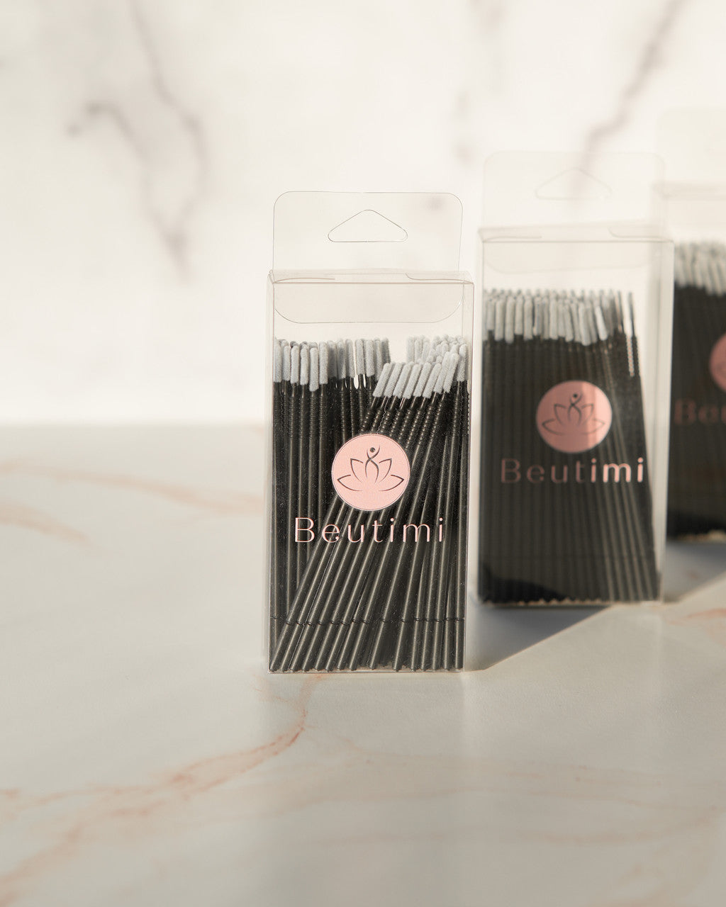 Beutimi Masterpiece Detailers 100-pack micro brush applicators in clear packaging with pink logo on marble surface