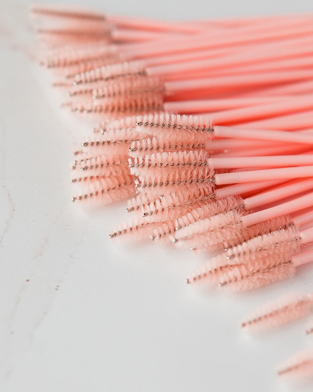 Beutimi Uplift Lash Spoolies in blush pink displayed in a fan arrangement showing soft bristle brushes for lash styling