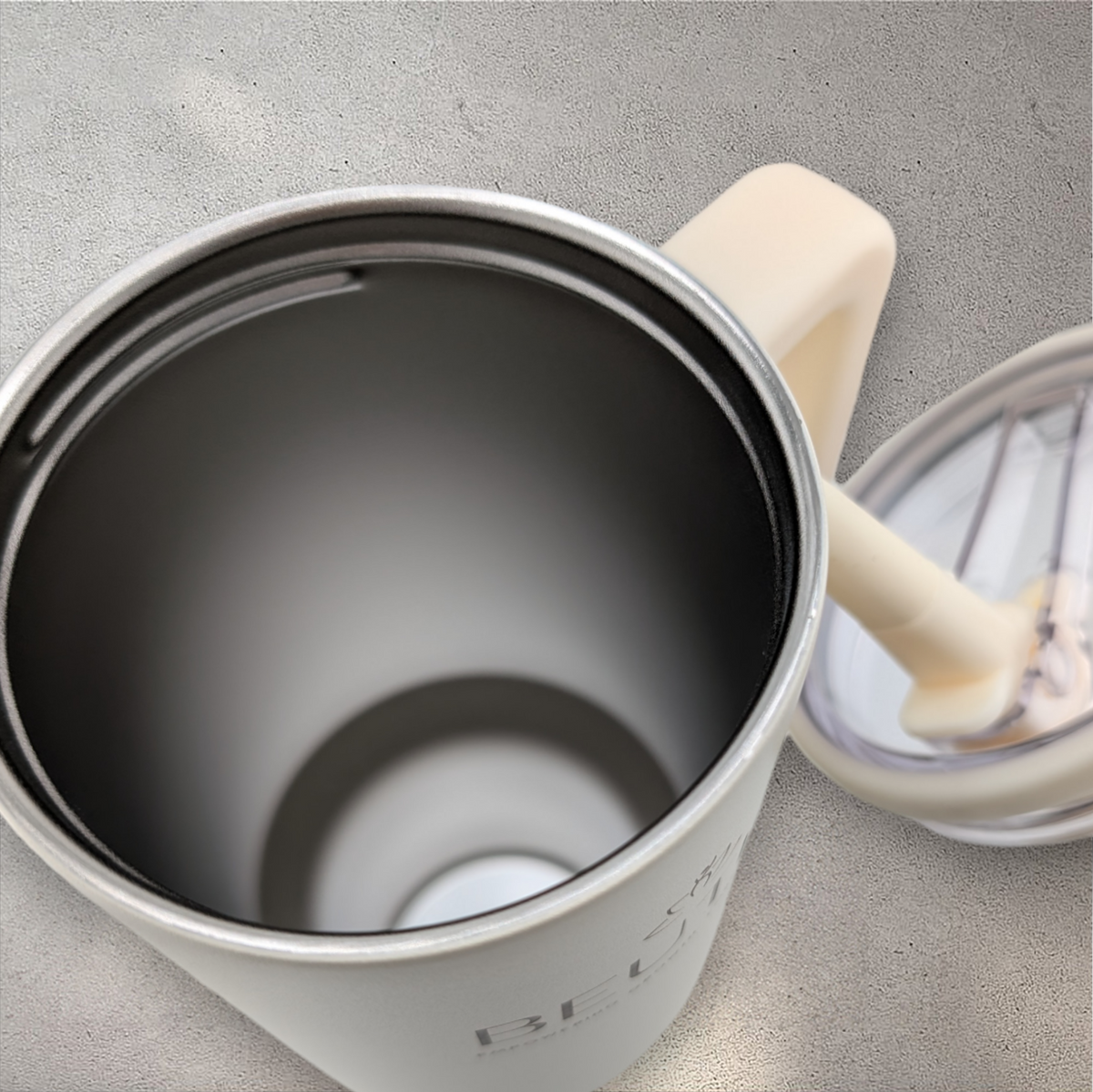 Beutimi Leakproof Hydrojug in cream with black interior and flip straw, shown open from above on gray surface