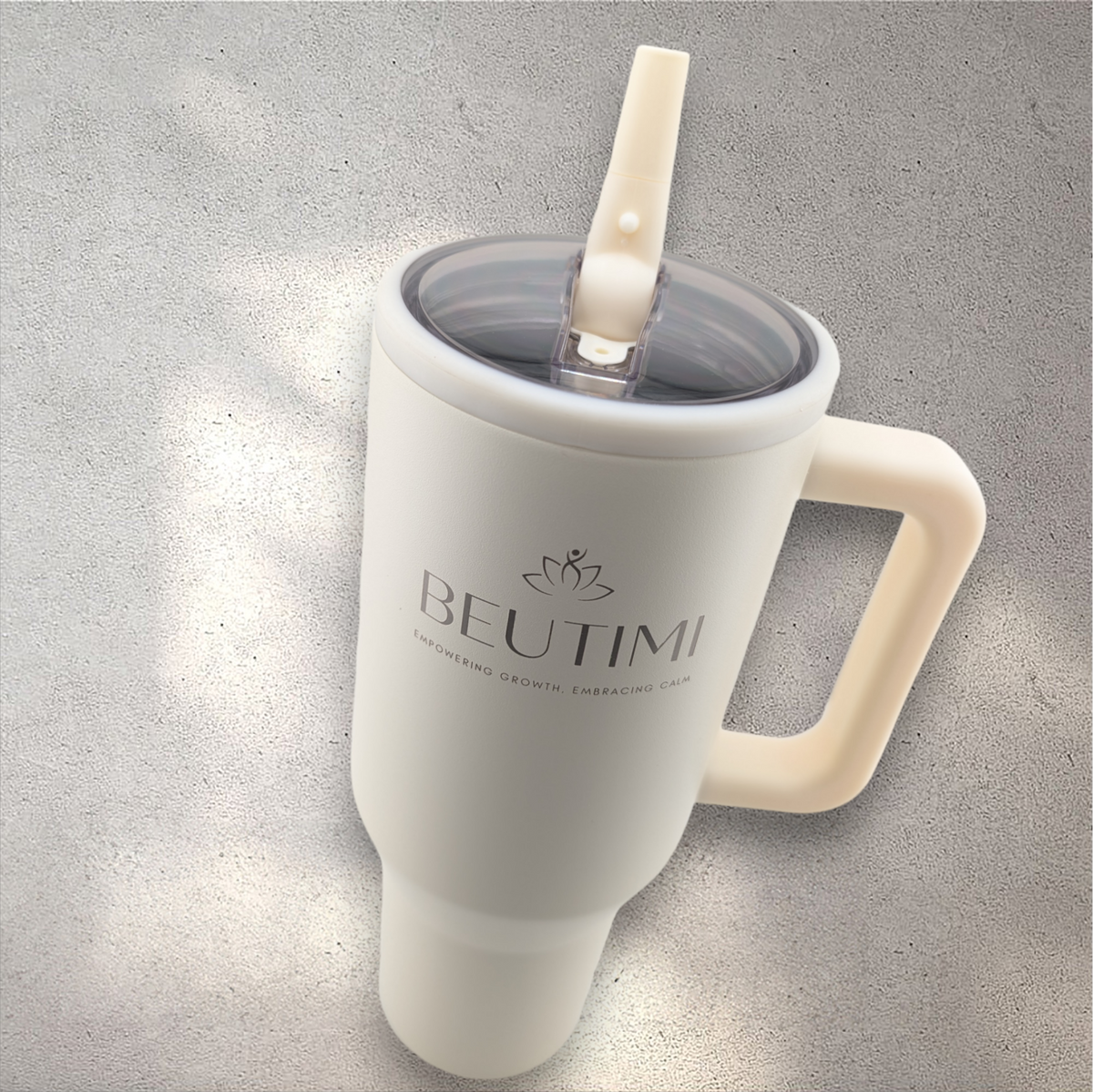 Cream-colored Beutimi Leakproof Hydrojug with flip straw and handle on concrete surface