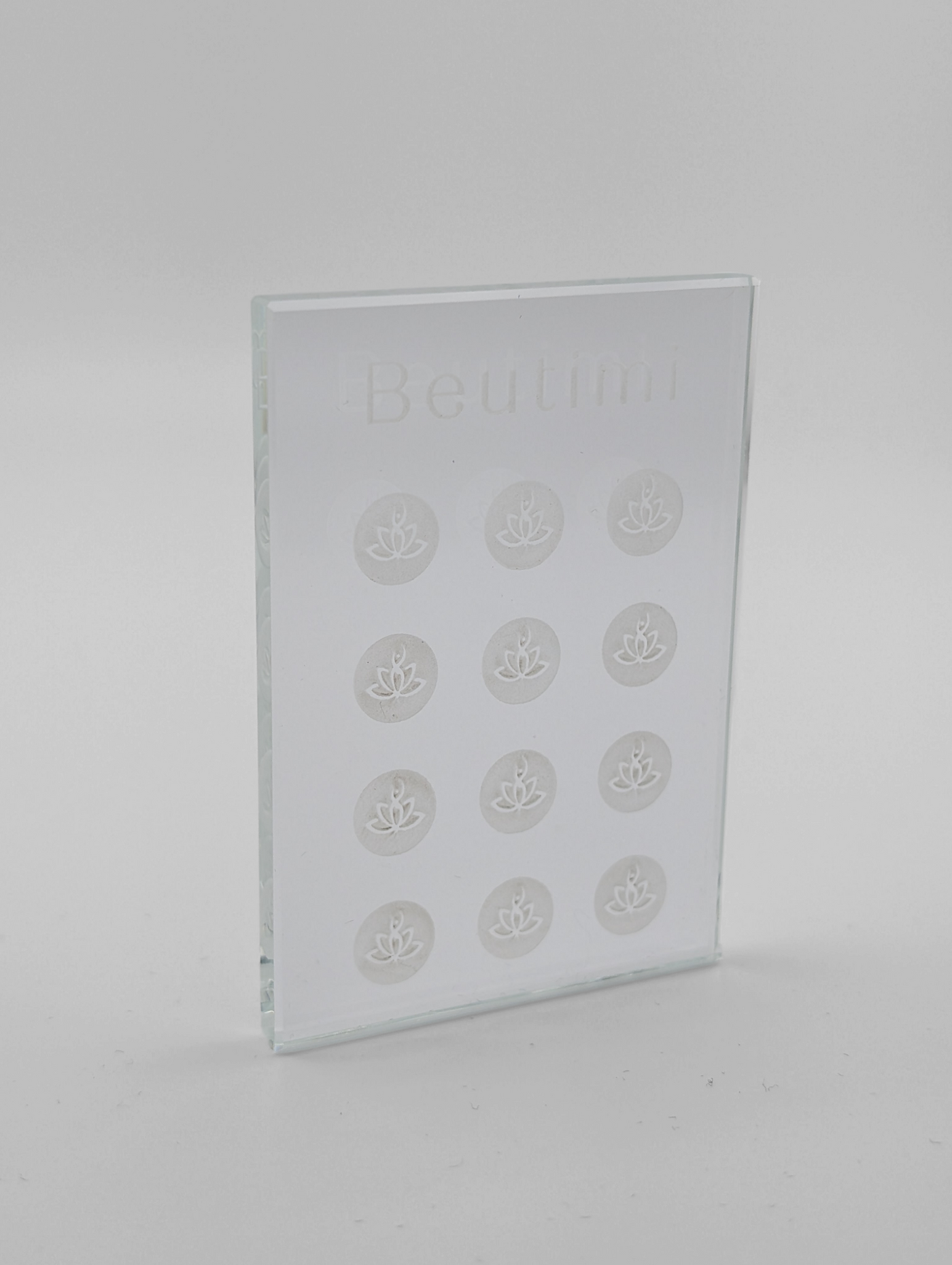 Beutimi Crystal Clear Adhesive Palette displayed as a transparent glass rectangle with twelve lotus flower designs arranged in rows
