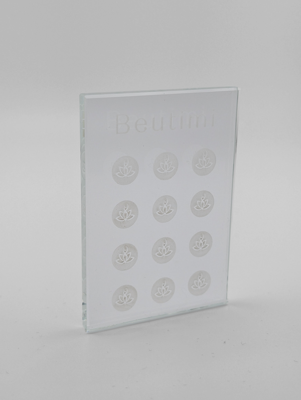 Beutimi Crystal Clear Adhesive Palette displayed as a transparent glass rectangle with twelve lotus flower designs arranged in rows