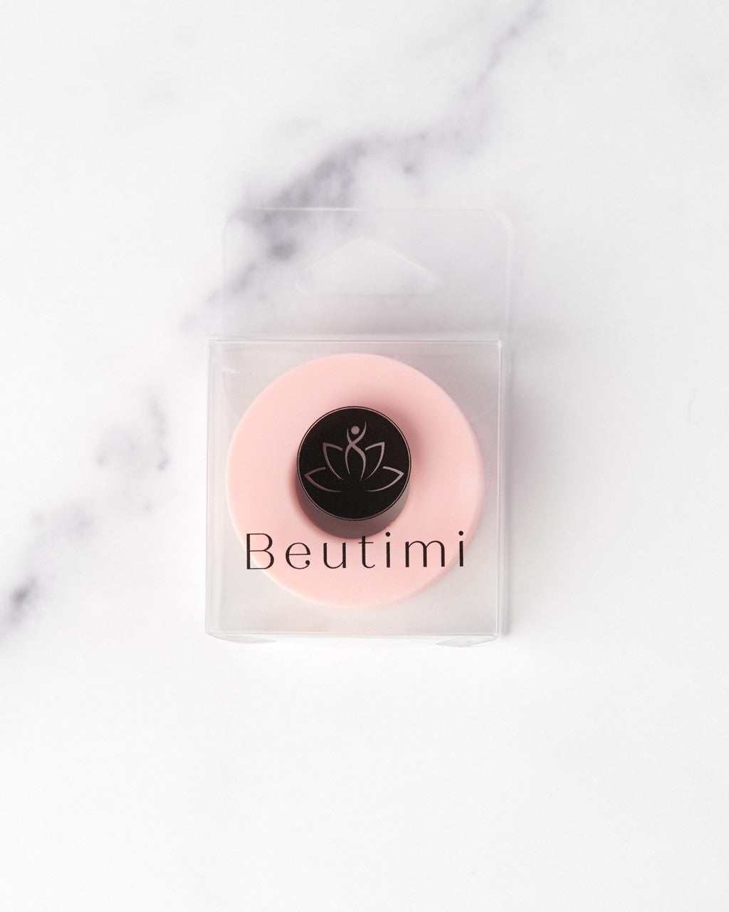 Beutimi Empower Gel Tape displayed in clear packaging with pink circular design and black lotus logo on marble background